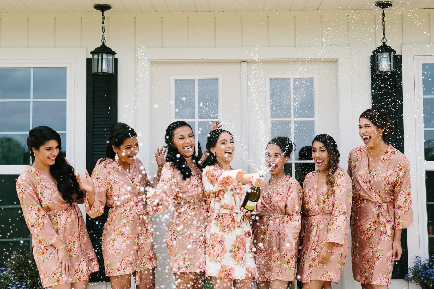 Bridesmaids having fun popping some champagne on the wedding day. October Oaks Wedding. Rustic Chic Celebration